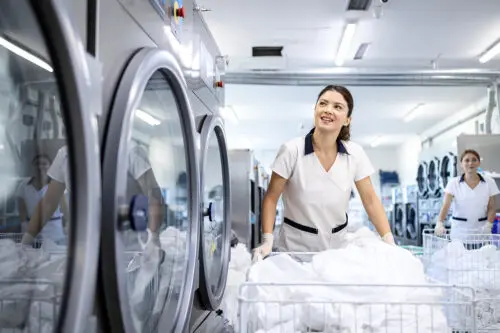 Female Dry Cleaning Worker Pushing Laundry Cart on Wheels