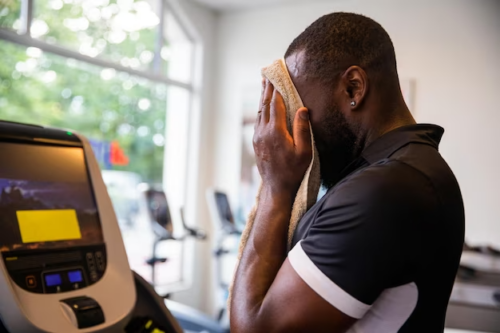 Guy Gym Wipes Sweat Off With Towel After Running Treadmill