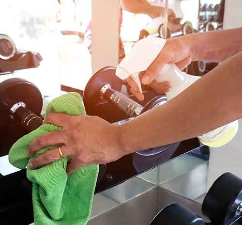 cleaning gym equipment with a microfiber towel